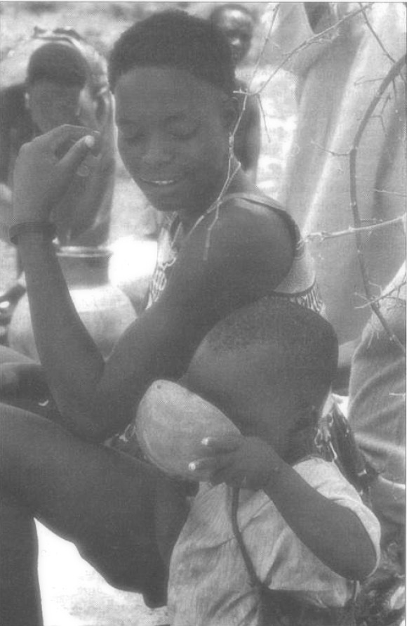 Kapsiki. Un enfant buvant de la bière à côté d'une mère ou soeur aïnée au marché de Mogodé, avril 1986 - © Van Beek 2005